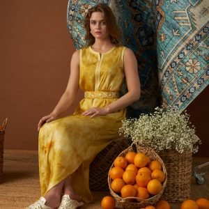 Yellow tie-dye sleeveless Moroccan kaftan with an embroidered belt cinching the waist